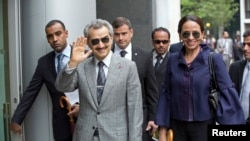 FILE - Prince Alwaleed bin Talal gestures as arrives at the High Court, London July 2, 2013.