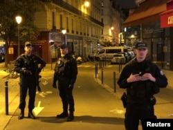 French police secure a street after a man killed a passer-by in a knife attack in Paris and injured four others before being shot dead by police, May 12, 2018.