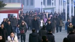 En esta captura de video, peatones desafían el frío mientras se abren camino a través de una plaza abierta, el jueves 30 de enero de 2020, en Pyongyang, Corea del Norte.