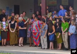 FILE - U.S. first lady Michelle Obama laughs with Peace Corps volunteers participating in a project in Kakata, some 70 kilometers from Liberia's capital of Monrovia, June 27, 2016.