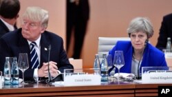 Presiden AS Donald Trump dan PM Inggris Theresa May dalam KTT G20 di Hamburg, Jerman Juli tahun lalu. Dalam beberapa hari ini May telah berulang kali berbicara dengan Trump mengenai penegakan "larangan penggunaan senjata kimia".