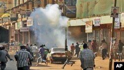 Ugandan protesters run after police fired tear gas during a demonstration against high food and fuel prices, in Kampala, Uganda, October 17, 2011.