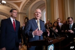 Senate Majority Leader Mitch McConnell, R-Ky., joined at left by Sen. John Barrasso, R-Wyo., speaks to reporters about the political battle for confirmation of President Donald Trump's Supreme Court nominee, Brett Kavanaugh, following a closed-door GOP policy meeting, at the Capitol in Washington, Oct. 2, 2018.