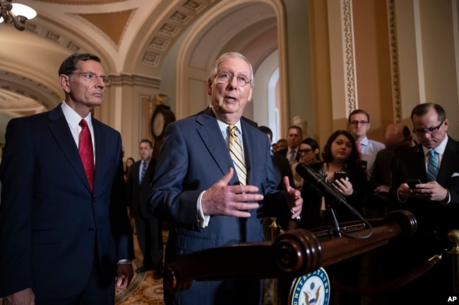 Senate Majority Leader Mitch McConnell, R-Ky., joined at left by Sen. John Barrasso, R-Wyo., speaks to reporters about the political battle for confirmation of President Donald Trump's Supreme Court nominee, Brett Kavanaugh, following a closed-door GOP policy meeting, at the Capitol in Washington, Oct. 2, 2018.