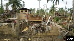 FILE - A resident stands inside a destroyed house in Loboc town, Bohol province, Philippines, on Dec. 21, 2021, days after super Typhoon Rai devastated the province.