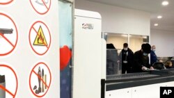 Passengers prepare to place items through Nuctech security scanners at the Brussels Eurostar train terminal on Jan. 17, 2022.