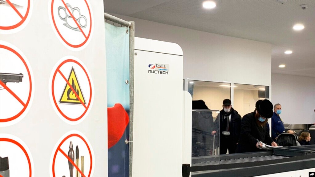 Passengers prepare to place items through Nuctech security scanners at the Brussels Eurostar train terminal on Jan. 17, 2022.