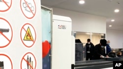 Passengers prepare to place items through Nuctech security scanners at the Brussels Eurostar train terminal on Jan. 17, 2022.