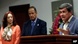 FILE - Pablo Beltran, the delegate of the Colombian rebel group ELN, right, talks as the Colombian government delegate Juan Camilo Restrepo, center, and Ecuador's Foreign Minister Fernanda Espinosa listen during a press conference at the foreign ministry in Quito, Ecuador, June 30, 2017.