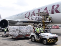 Pekerja mengenakan masker pelindung menurunkan Moderna hasil kerjasama internasional Indonesia-Amerika Serikat melalui fasilitas multilateral COVAX, di terminal kargo Soekarno Hatta International, 11 Juli 2021. (Foto: Courtesy Biro Pers via Reuters)