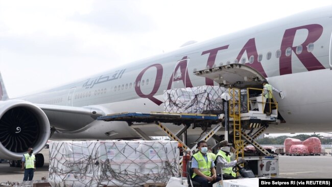 Pekerja mengenakan masker pelindung menurunkan Moderna hasil kerjasama internasional Indonesia-Amerika Serikat melalui fasilitas multilateral COVAX, di terminal kargo Soekarno Hatta International, 11 Juli 2021. (Foto: Courtesy Biro Pers via Reuters)