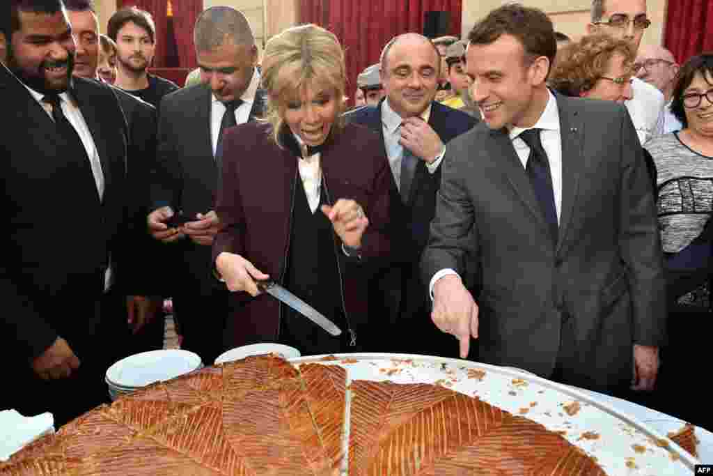 French president Emmanuel Macron and his wife Brigitte cut slices of a traditional epiphany cake during a ceremony at the Elysee palace, Paris.