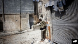 A Free Syrian Army fighter fires his weapon toward Syrian Army positions in Karmal Jabl district in Aleppo, Syria, Oct. 21, 2012. 