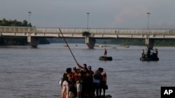 Migrants cross by raft from Tecun Uman, Guatemala, left, to Ciudad Hidalgo, Mexico, on June 14, 2019. 