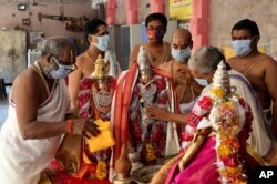 Hindu priests wearing face masks perform rituals during the Ram Navami festival at a temple closed for devotees as part of lockdown to curb the spread of new coronavirus in Hyderabad, India, April 2, 2020.