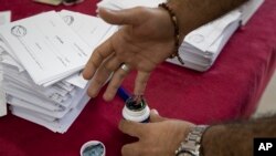 Seorang pria Suriah menorehkan jarinya setelah melakukan voting di tempat pemungutan suara dalam Pilpres di ibu kota Suriah, Damaskus, Suriah, Rabu, 26 Mei 2021. (AP Photo/Hassan Ammar)