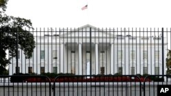 FILE - A perimeter fence sits in front of the White House fence on the North Lawn along Pennsylvania Avenue in Washington, Sept. 22, 2014.