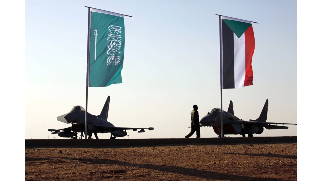 Personel militer berjalan melewati bendera Arab Saudi dan Sudan ketika Presiden Sudan Omar Ahmed al-Bashir menghadiri latihan militer bersama Angkatan Udara Saudi dan Angkatan Udara Sudan di Bandara Merowe di Merowe, Negara Bagian Utara, Sudan 9 April 2017. (Foto: dok).