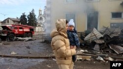 Una residente local y su hijo pasan por la estación de tren destruida por un ataque con misiles rusos en Kostyantynivka, región de Donetsk, el 25 de febrero de 2024, en medio de la invasión rusa de Ucrania.