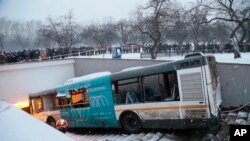 Des piétons se tiennent autour de la scène d'un accident de bus à Moscou, Russia, 25 Dec. 2017.