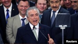 Le président intérimaire Michel Temer, entouré d'hommes, donne son premier discours public après sa nomination à Brasilia, Brésil, 12 mai 2016. 