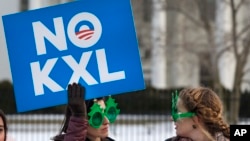 Two women wearing sunglasses with a tree design join other opponents of the Keystone XL pipeline to celebrate President Barack Obama's veto of legislation pertaining to the project outside the White House in Washington, Feb. 24, 2015.