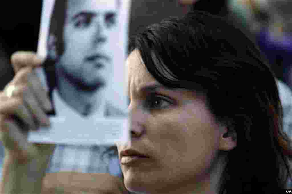 The relative of a victim killed during Argentina's dirty war holds his picture as she listens to the sentence for former dictator Jorge Videla in Cordoba, Argentina, Wednesday Dec. 22, 2010. Videla was sentenced to life in prison Wednesday for the tortur