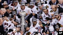 The Chicago Blackhawks pose with the Stanley Cup after beating the Boston Bruins 3-2 in Game 6 of the NHL hockey Stanley Cup Finals, June 24, 2013, in Boston.