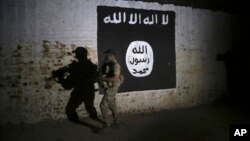 FILE - An Iraqi soldier inspects a recently-discovered train tunnel, adorned with an Islamic State group flag, that belonged to the former Baghdad to Mosul line, that was turned into a training camp for IS fighters, in western Mosul, Iraq, March 1, 2017.