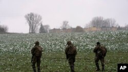 Soldados polacos buscan restos de misiles cerca del lugar donde cayó un misil en un campo labrado cerca de la aldea de Przewodow, Polonia, 17 de noviembre de 2022.