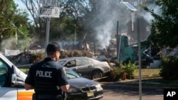 A police officer guards the remains of a house that exploded, likely due to gas line issues caused by severe flooding from Tropical Storm Ida, in Manville, New Jersey, Sept. 3, 2021. 