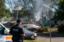 Seorang petugas polisi menjaga sisa-sisa rumah yang meledak, kemungkinan karena masalah saluran gas yang disebabkan oleh banjir parah dari Badai Tropis Ida, di Manville, New Jersey, 3 September 2021. (Foto: AP)