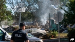 A police officer guards the remains of a house that exploded, likely due to gas line issues caused by severe flooding from Tropical Storm Ida, in Manville, New Jersey, Sept. 3, 2021. 