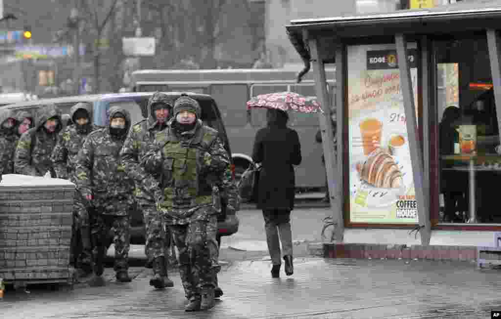 Self-defense activists pass by the Dnipro Hotel in Kyiv, April 1, 2014. 