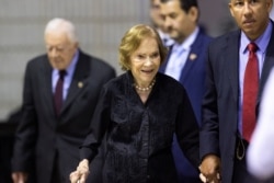 FILE - Former first lady Rosalynn Carter arrives with husband former President Jimmy Carter, left, for an annual Carter Town Hall held at Emory University Sept. 18, 2019, in Atlanta.