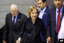 FILE - Former first lady Rosalynn Carter arrives with husband former President Jimmy Carter, left, for an annual Carter Town Hall held at Emory University Sept. 18, 2019, in Atlanta.