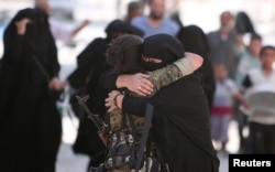 A woman embraces a Syria Democratic Forces (SDF) fighter after she was evacuated with others by the SDF from an Islamic State-controlled neighborhood of Manbij, in Aleppo Governorate, Syria, Aug. 12, 2016.