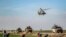 A Russian Mil Mi-17 military helicopter flies over a joint Russian-Turkish military patrol convoy in the countryside near Darbasiyah along the border with Turkey in Syria's northeastern Hasakah province.
