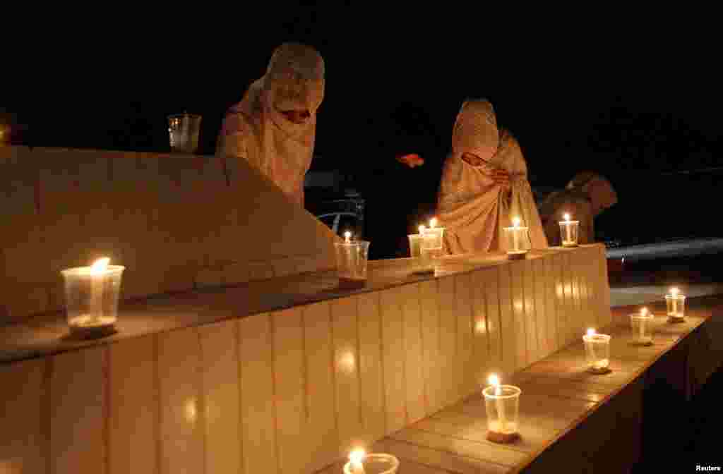 Women light candles during a candlelight vigil in honor of philanthropist Abdul Sattar Edhi in Quetta, Pakistan.