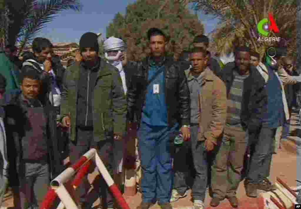 Unidentified former hostages pose for the media in Ain Amenas, Algeria, in this image taken from television , January 18, 2013. (Canal Algerie) 