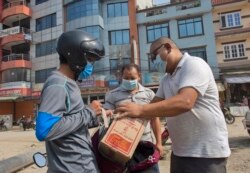 Sherpa, center, delivers food to fellow guides in Kathmandu, Nepal, Monday, June 7, 2021. (AP Photo/Bikram Rai)