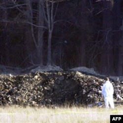 An emergency worker in a Pennsylvania field looks at the crater made by the crash of a plane hijacked by Islamic terrorists. People on the flight had rebelled.