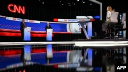 CNN journalists Jake Tapper and Dana Bash (R) moderate the first presidential debate of the 2024 elections between US President Joe Biden and former US President and Republican presidential candidate Donald Trump at the CNN's studios in Atlanta, Georgia, 