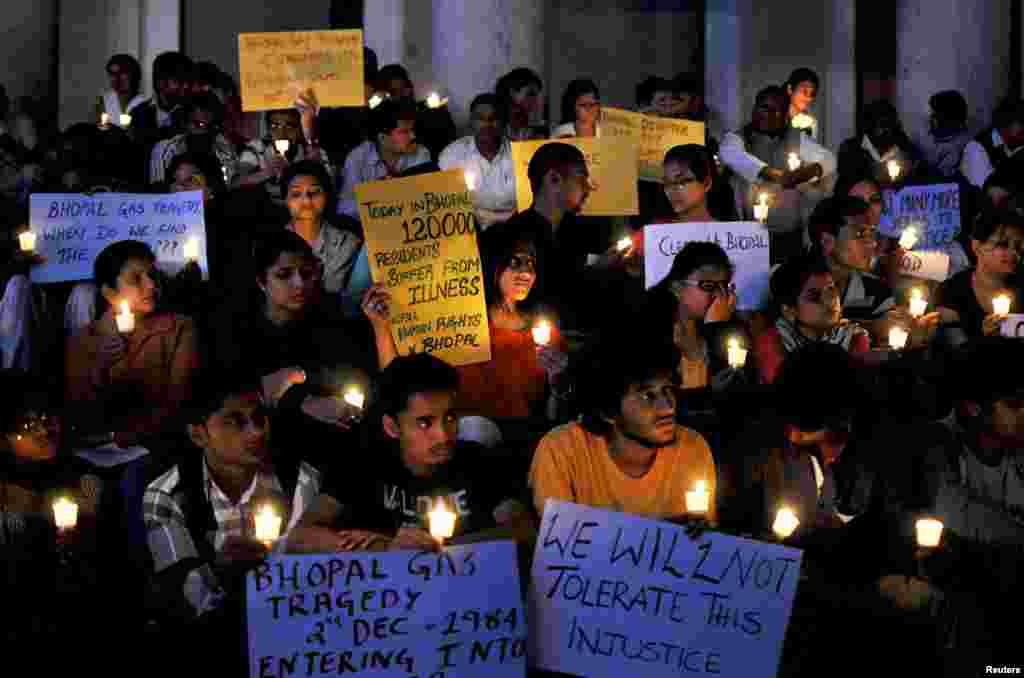 Activists from Bengaluru Solidarity Group, a social group, hold candles and placards during a vigil to commemorate the 30th anniversary of Bhopal gas tragedy, in the southern Indian city of Bengaluru, previously known as Bangalore, Dec. 2, 2014. 