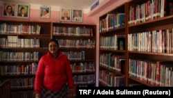 Meera Marahattha stands surrounded by books in the Tribeni community library in Bhimdhunga, Nepal, Feb. 9, 2018. 