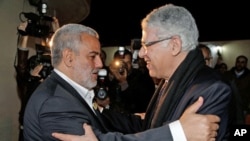 Morocco's newly-appointed moderate Islamist Prime Minister Abdelilah Benkirane (L) greets outgoing Prime Minister Abbas Fassi at the Justice and Development Party headquarters in Rabat, Morocco, November 30, 2011.