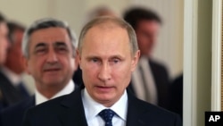 Russian President Vladimir Putin, followed by Armenian President Serge Sarkisian, enters a hall during a meeting outside Moscow on Sept. 3, 2013.