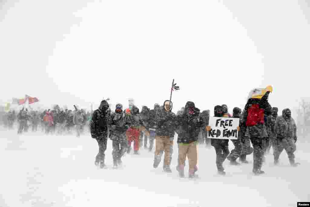 Veterans and activists march just outside the Oceti Sakowin camp during a snow fall as &quot;water protectors&quot; continue to demonstrate against plans to pass the Dakota Access pipeline adjacent to the Standing Rock Indian Reservation, near Cannon Ball, North Dakota, Dec. 5, 2016.
