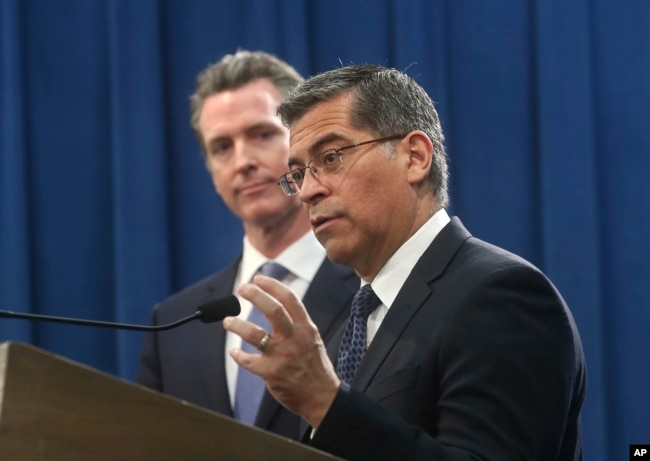 FILE - California Attorney General Xavier Becerra, right, accompanied by Gov. Gavin Newsom, Feb. 15, 2019, in Sacramento, California.