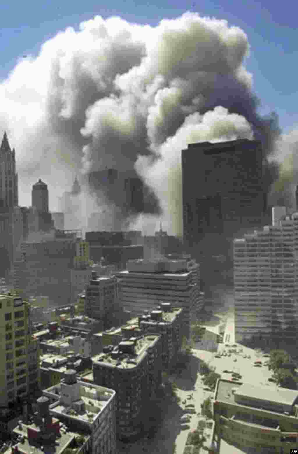 Smoke rises following the collapse of the World Trade Center towers in New York on Sept. 11, 2001. The skyscraper in the center right of the photo, 7 World Trade Center, also collapsed later on Sept. 11. (AP Photo/Suzanne Plunkett)